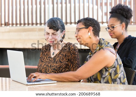 Closeup portrait, multigenerational family looking at something exciting on laptop, isolated outdoors background