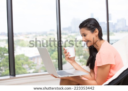 Closeup portrait, young, attractive wife, mother ,with white cup, smiling looking at laptop. Isolated glass window indoor green trees background. woman in world of technology concept