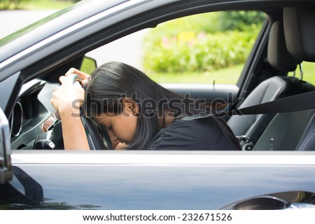 Closeup portrait tired young attractive woman with short attention span, driving her car after long hours trip, trying to stay awake at wheel, isolated outside background. Sleep deprivation