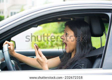 Closeup portrait, young woman driving in black car and checking her phone, then shocked almost about ot have traffic accident, isolated outdoors background