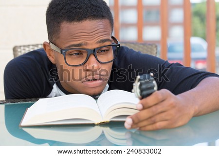 Closeup portrait, nerdy young man in big black glasses holding watch, falling very tired of reading, isolated outdoors outside background. The clock is ticking, can\'t focus