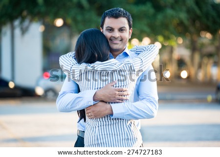 Closeup portrait back view, young couple in blue shirt, hugging, smiling, isolated outdoors outside background. Happy moments, positive emotions