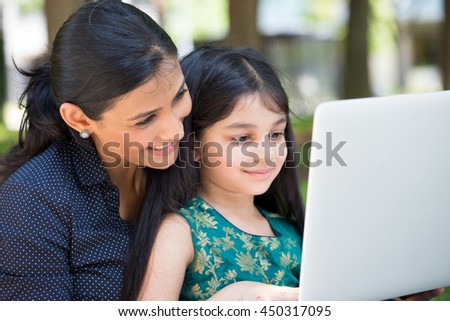 Closeup portrait, family looking at silver laptop together, isolated outdoors outside background