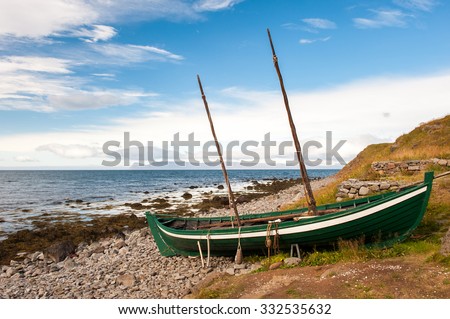 Old fishing boat, boat of the Vikings on the ocean shore, Iceland