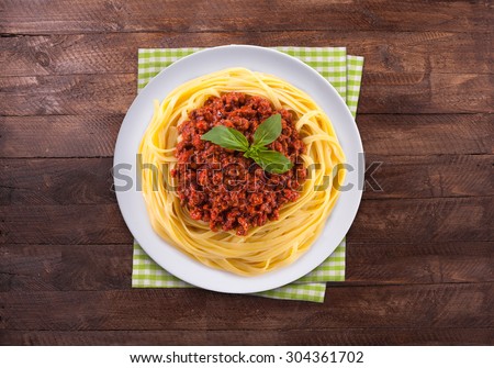 Spaghetti bolognese on the wooden table. Top view with copy space.