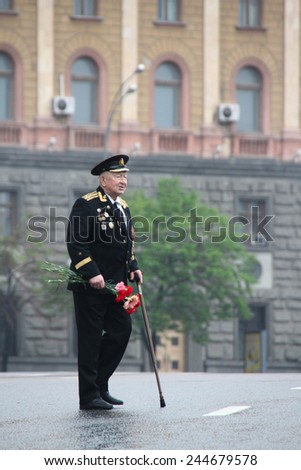 Moscow, Russia - May 9, 2012. March of communists on the Victory Day. The unknown old man the veteran of war with awards, with flowers and in a uniform, in day of procession of communists