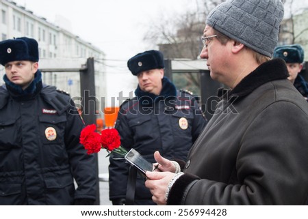 Moscow, Russia - March 1, 2015. Participant of mourning march of memory of Boris Nemtsov and police. March to the memory of Boris Nemtsov, Russian opposition leader who was assassinated on the eve of