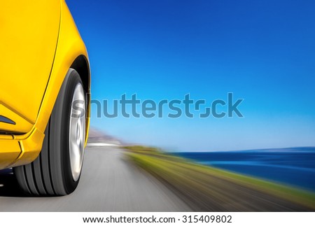 Driving sports car fast on the road by the sea