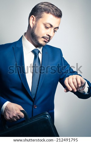 Handsome corporate businessman checking the time on his watch