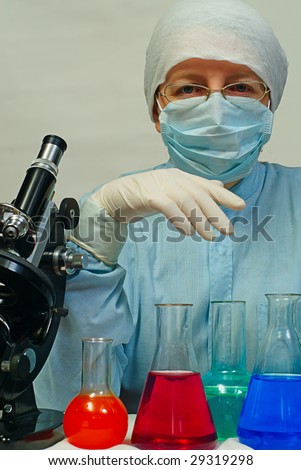 woman laboratory assistant whit chemical glasses and microscope