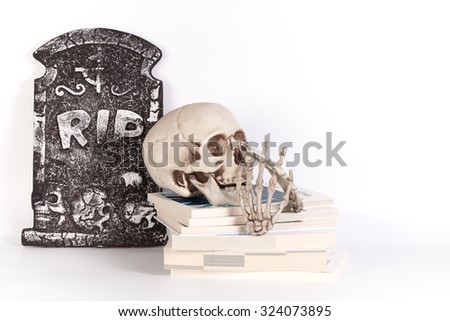 Skull and books isolated on white background and grave yard
