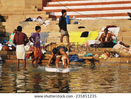 VARANASI, INDIA - OCTOBER 23: Unidentified Indian people wash clothed in Ganga river in Varanasi, India. For many dwellers of Varanasi the Ganga is only way to wash clothes.
