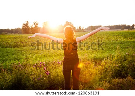 Beautiful girl in the meadow enjoying the sun