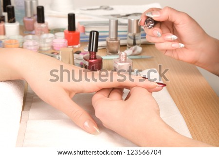 Woman\'s hands with nail brush drawing on nails