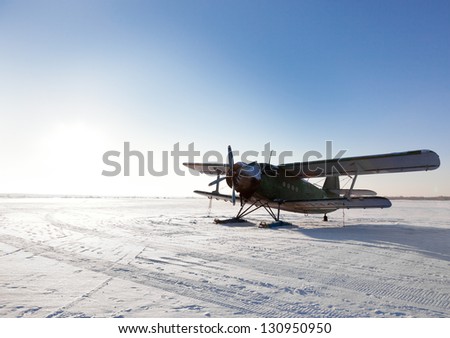Old airplane parked on little north snowy airfield