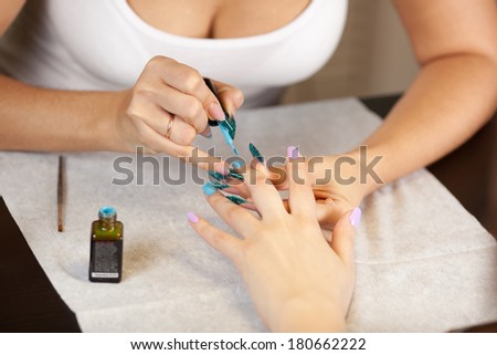 Beautician doing manicure with nail varnish