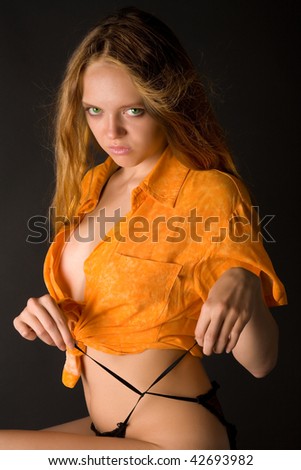 Woman in orange shirt ties bretelle on her pants