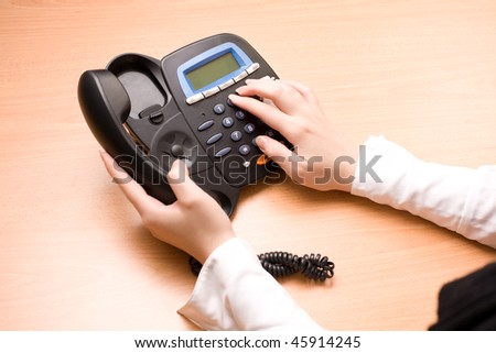 Woman\'s hands with telephone in the office