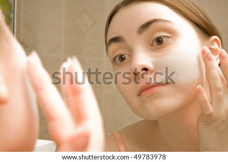Woman doing facial mask to her face
