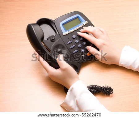Woman's hands with telephone in the office