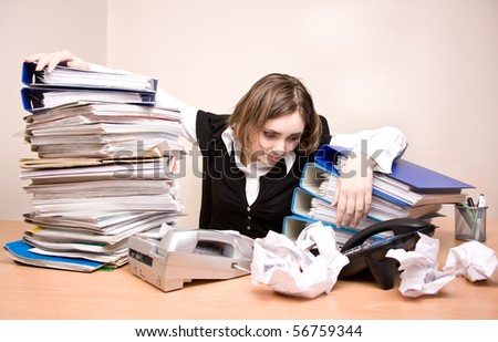 Young businesswoman with tons of documents at office