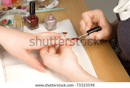 Woman\'s hands with nail brush drawing on nails