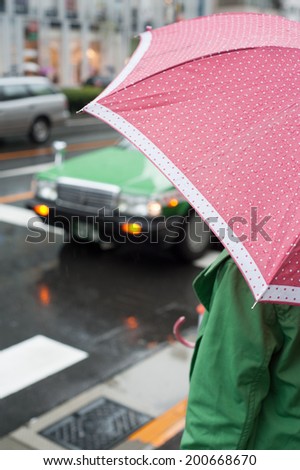 Woman in a green coat with pink umbrella in Aoyama, Tokyo, Japan