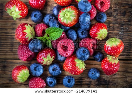 Berry fruits on wooden background or table. Blueberries, raspberries, strawberries, Forest fruits. Gardening ,agriculture,harvest and forest concept.