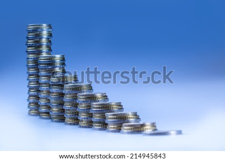 Financial diagram - the graph of economic growth. Euro coins stacked in columns in order from smallest to largest. Blue background.