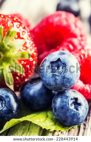 Berry fruits on wooden background or table. Blueberries, raspberries, strawberries, Forest fruits. Gardening ,agriculture,harvest and forest concept.