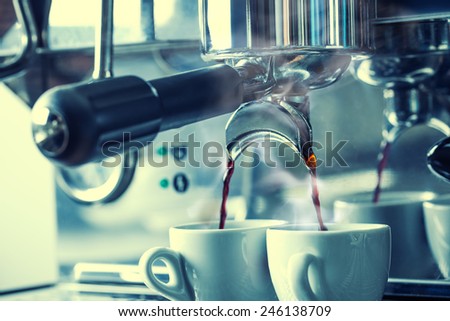 Preparation of two espresso in coffee machines.Professional coffee machine making espresso in a Two cafe.Rising steam