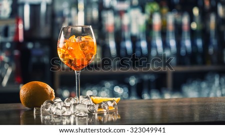 Aperol Spritz Cocktail. Alcoholic beverage based on bar counter with ice cubes and oranges.