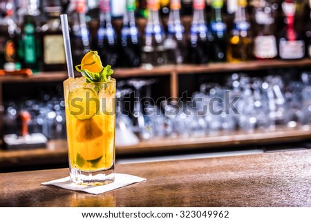 Fresh cocktail with orange, limet, mint and ice. Alcoholic, non-alcoholic drink-beverage at the bar counter in the night club.