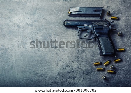 9 mm pistol gun and bullets strewn on the table.