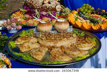 Ukrainian dumplings with bacon, sour cream, served with fruit and pastries in national style