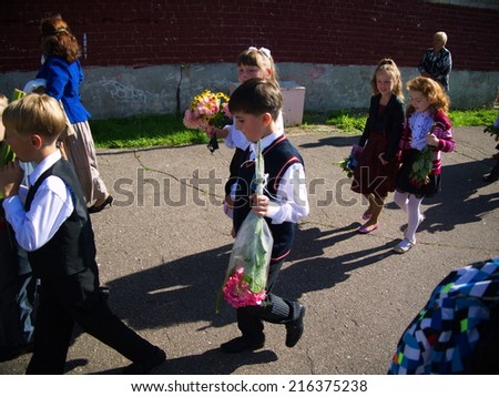 LATVIA, RIGA - September 1, 2014:  Children with flowers in front of the School No. 68 on the first day of school on September 1, 2014 in Riga, Latvia.
