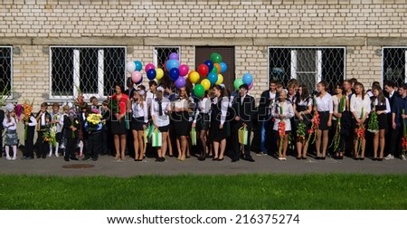 LATVIA, RIGA - September 1, 2014:  Children with flowers in front of the School No. 68 on the first day of school on September 1, 2014 in Riga, Latvia.