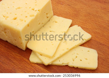 Piece of cheese sliced on a wooden board