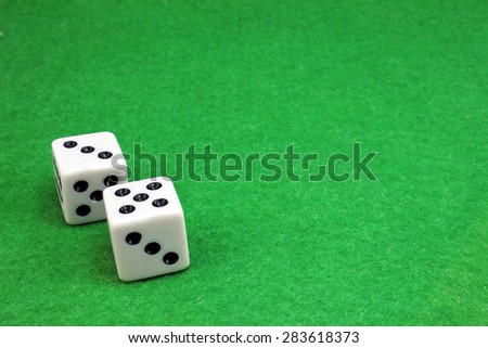 Two dice for a game of dice on a green cloth