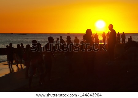 Young people having party on the beach during the sunset