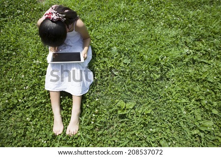Girl to operate the tablet-type device in the park
