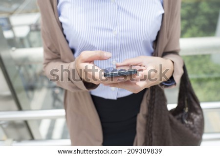 Career woman to operate a smartphone