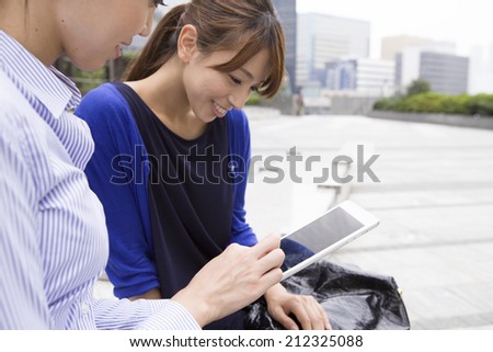 Women talk while watching the tablet