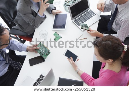 Business people studying the circuit board