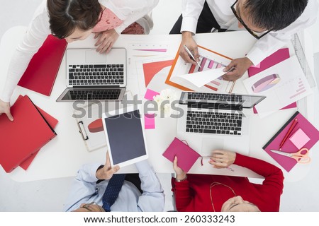Above view of business team sitting around table and working