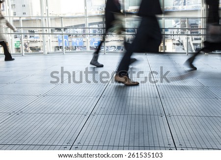 Fast Paced Business World with Blurred Motion. People walking. All exposed faces are motion blurred.