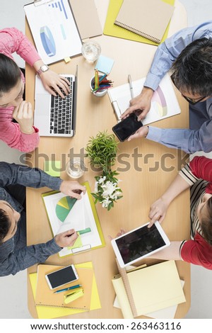 Creative work. Top view of business people working together while sitting at the table