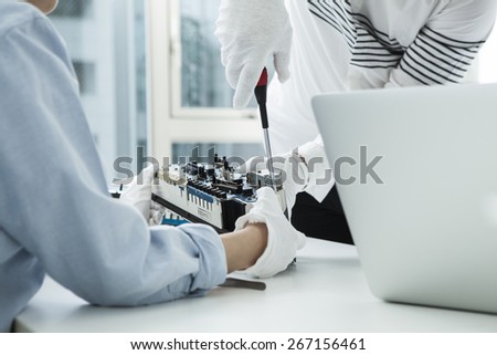 Businessman and businesswoman using a flathead screwdriver to fix cars meter