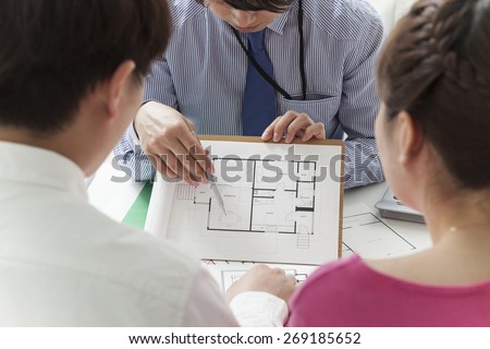 Couple discussing with consultant, real estate agent or architect