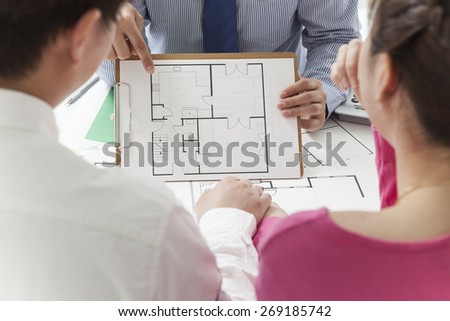Real-estate agent shows a build project to a young couple
